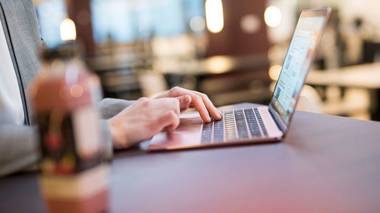 Hands typing on a laptop