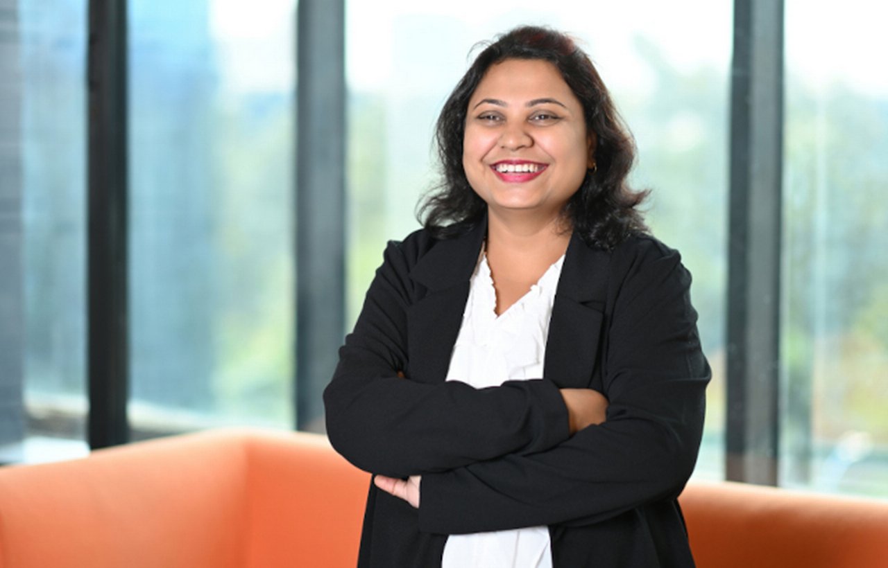 Woman stands close to window smiling