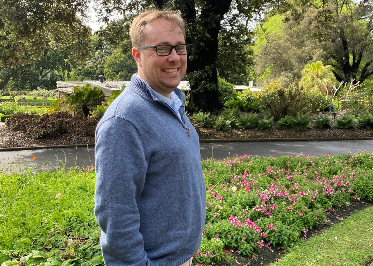 Nic in front of a garden