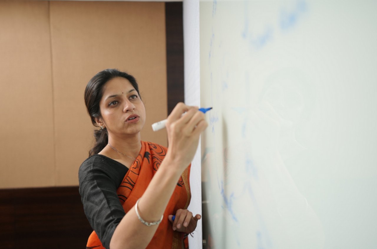 a woman writing something on a whiteboard