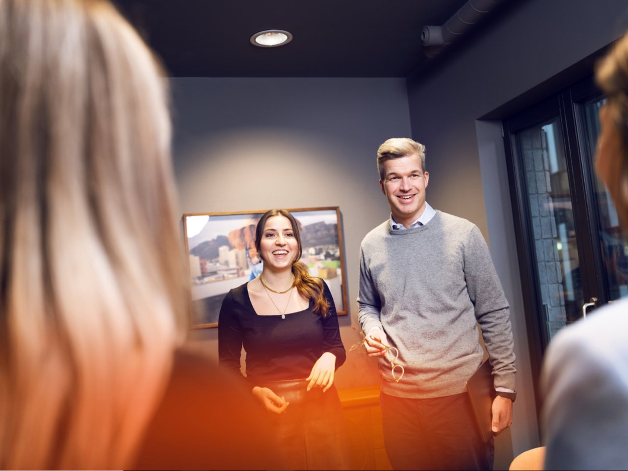Collegues standing in the room and smiling