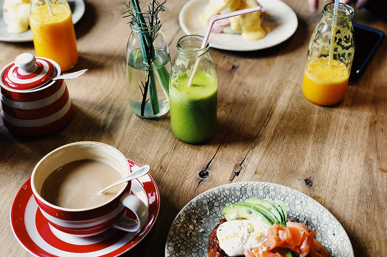 A healthy breakfast of coffee and green smoothie on a table