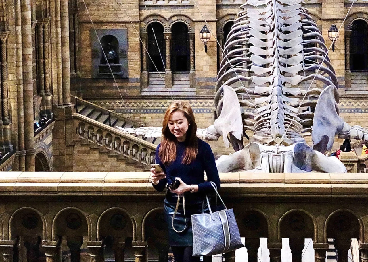 Queenie im Museum Skelett des Dinosauriers im Hintergrund