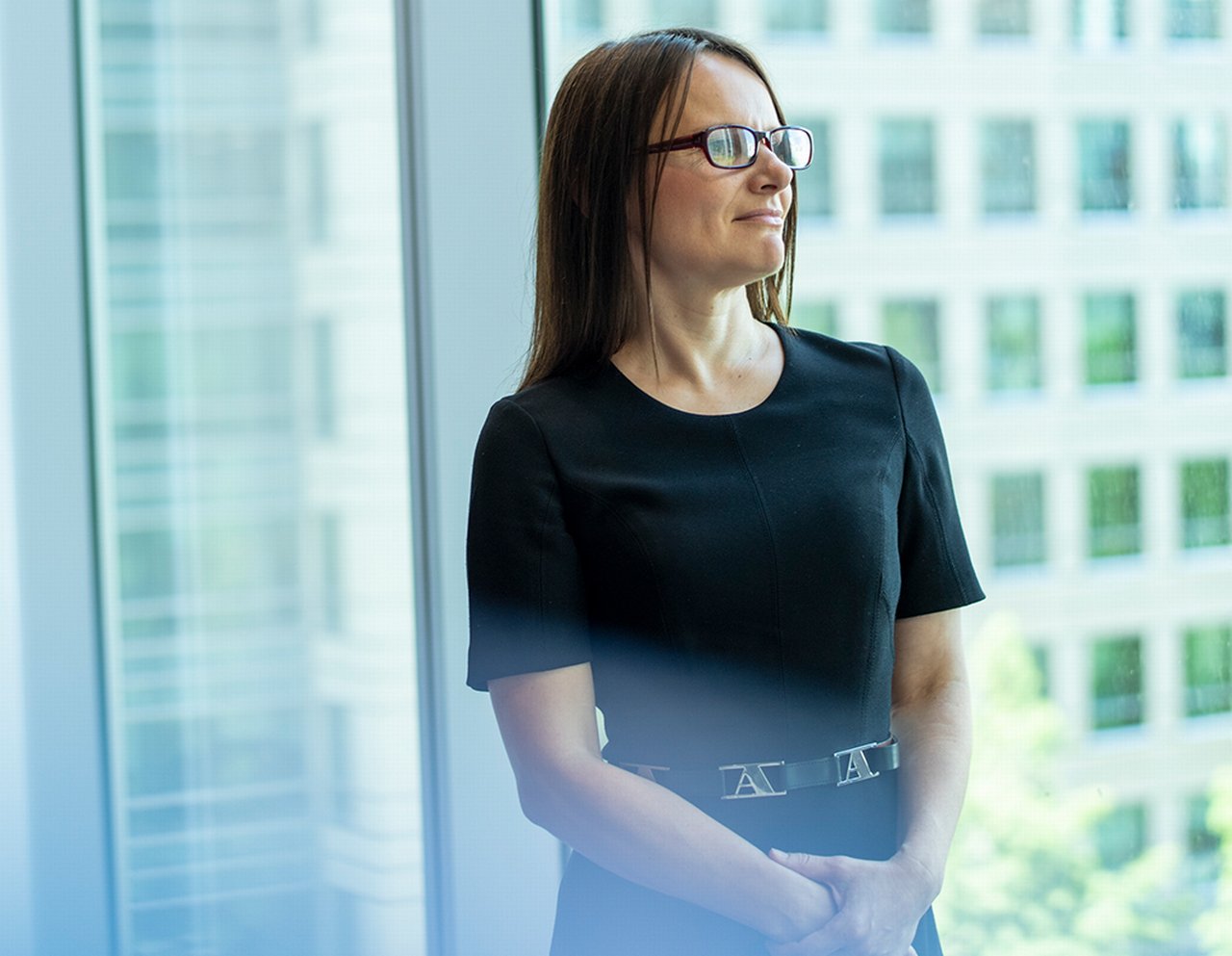 Portrait of Nathalia standing in front of a glass cube wall