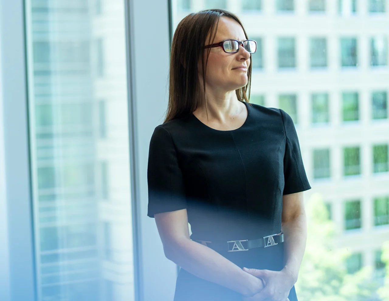 Portrait of Nathalia standing in front of a glass cube wall