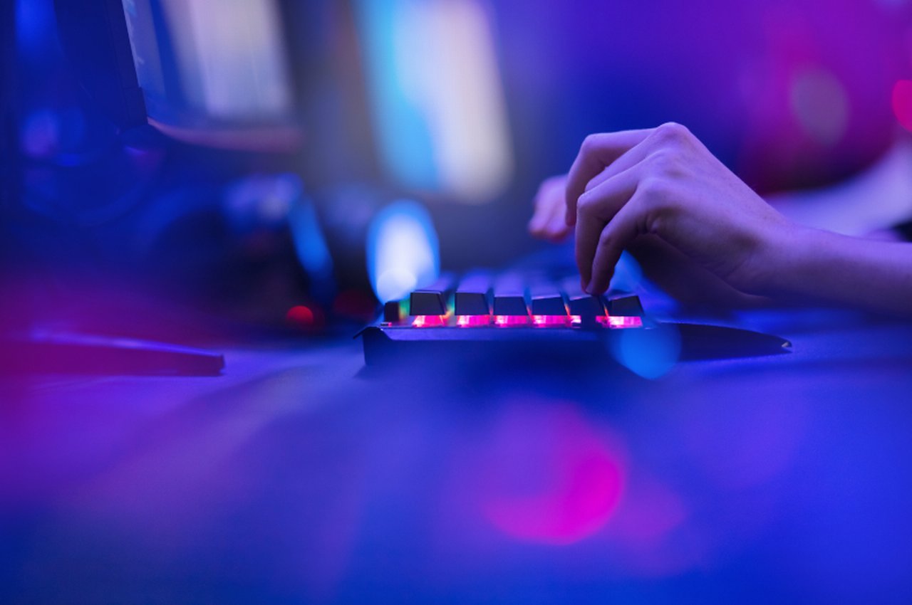 a hand on a glowing keyboard