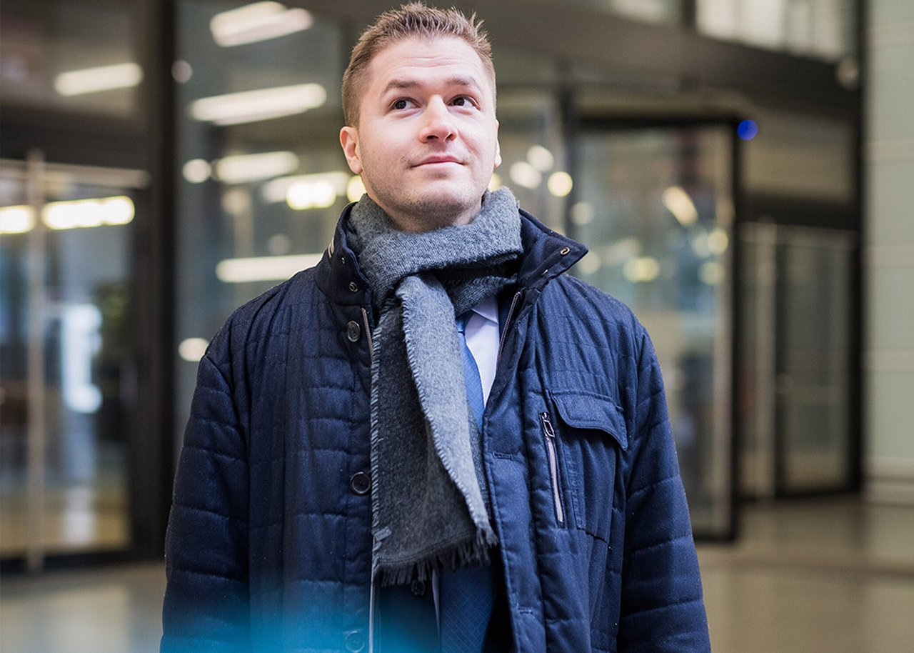 Stevan steht in einem Foyer und schaut nach oben