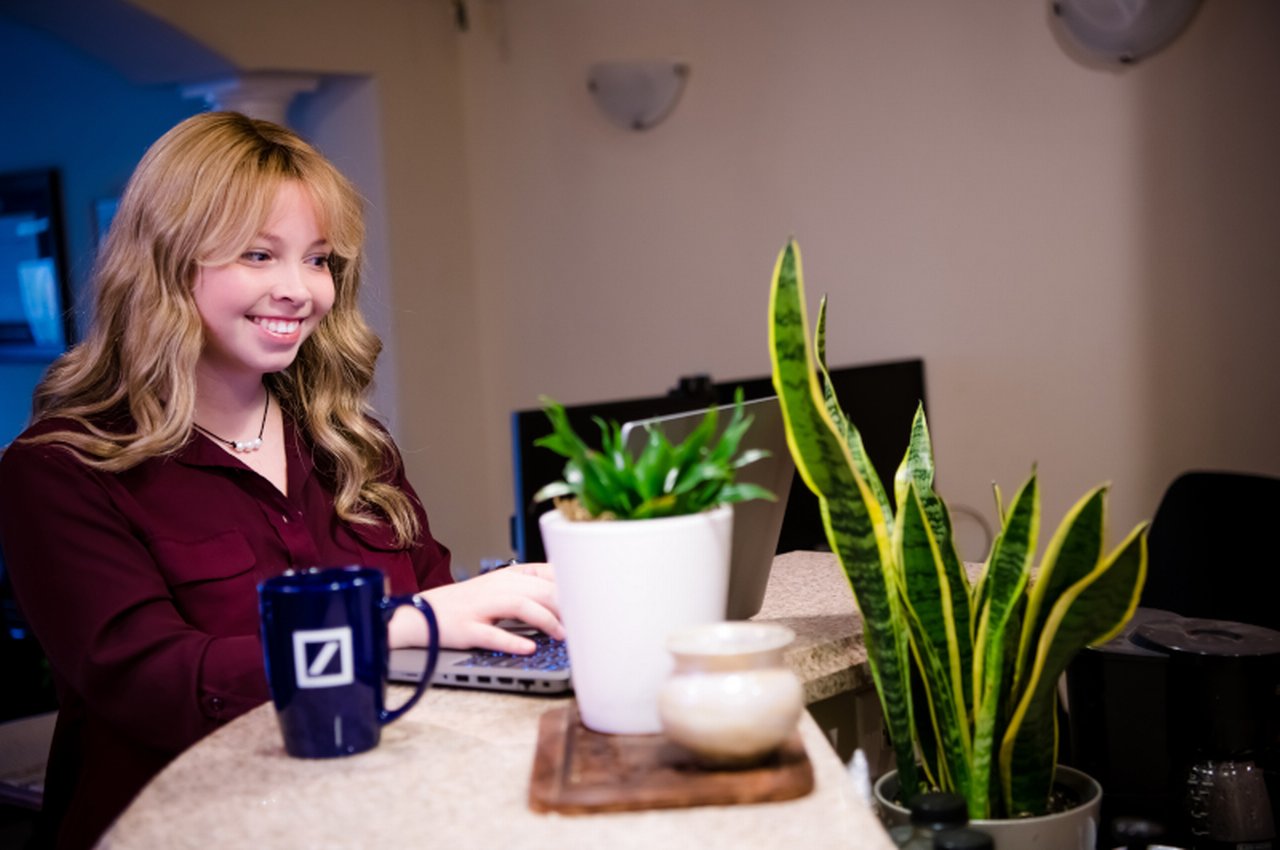 Woman standing behind the desk plants infront of her