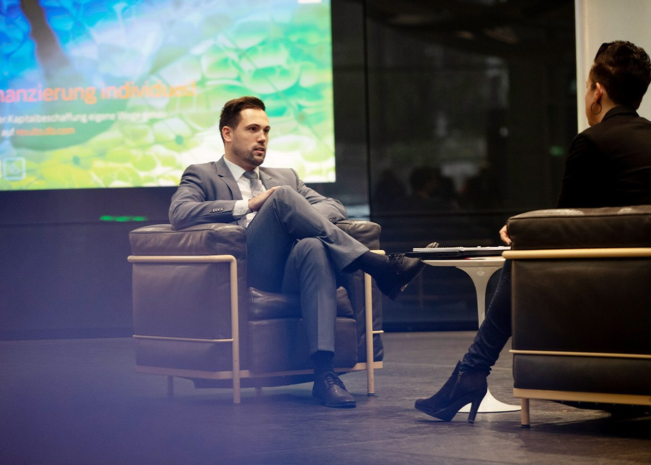 Two colleagues sitting having a discussion infront of a large screen