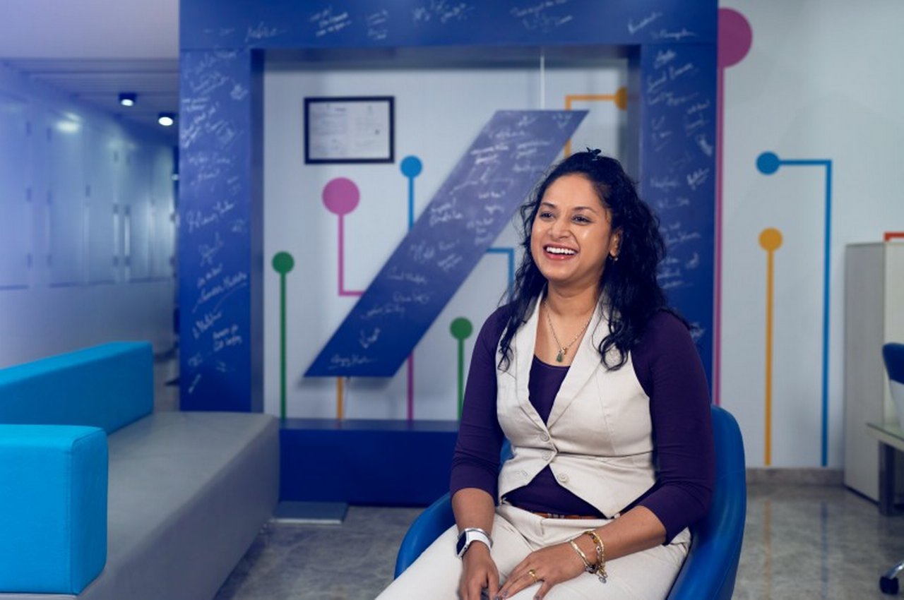 smiling woman in front of Deutsche Bank Logo