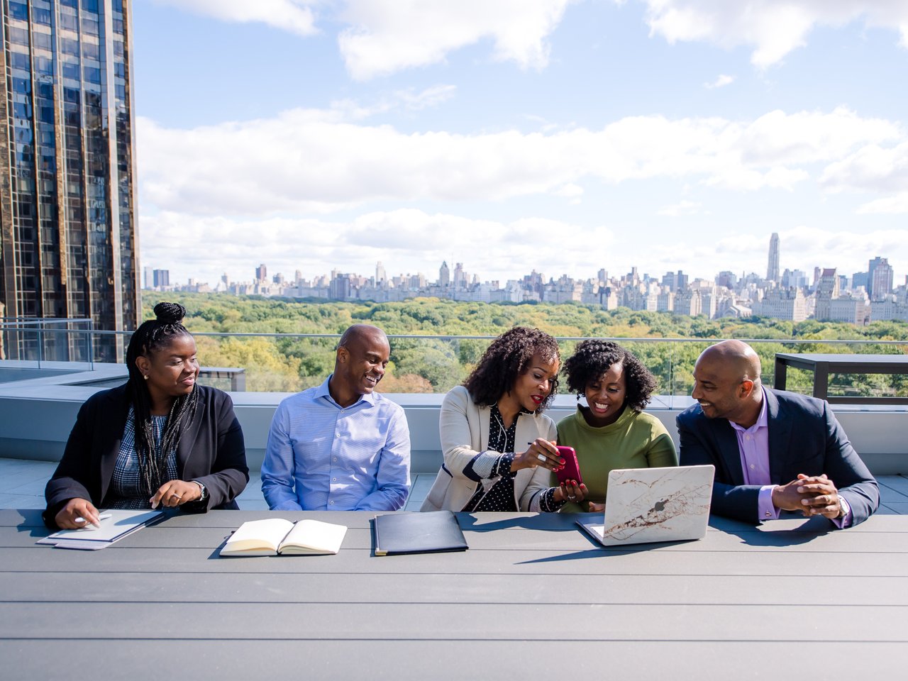 Collegues at the meeting on the terrace with the wiev on New York behind them