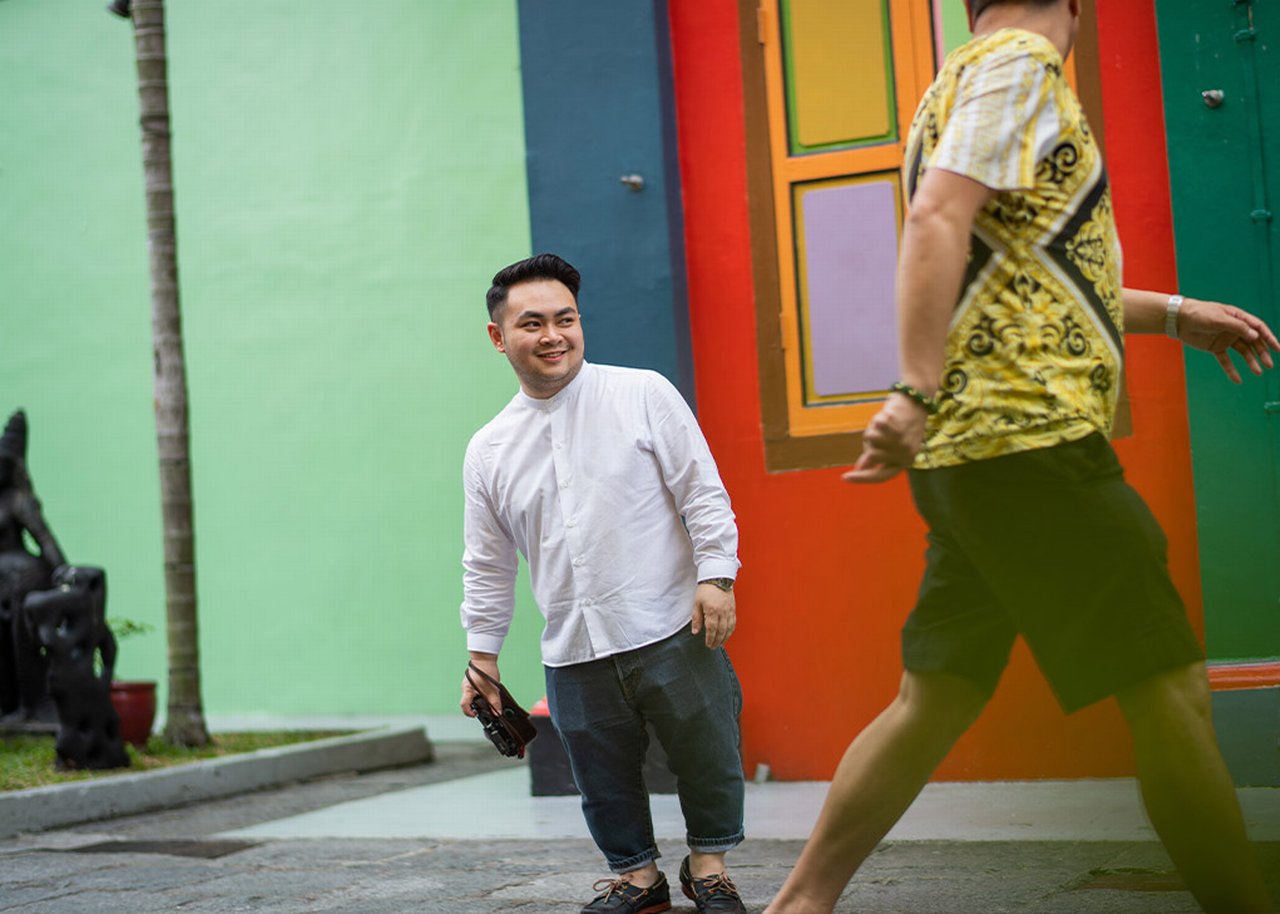 Bryan with a camera in front of colorful wall