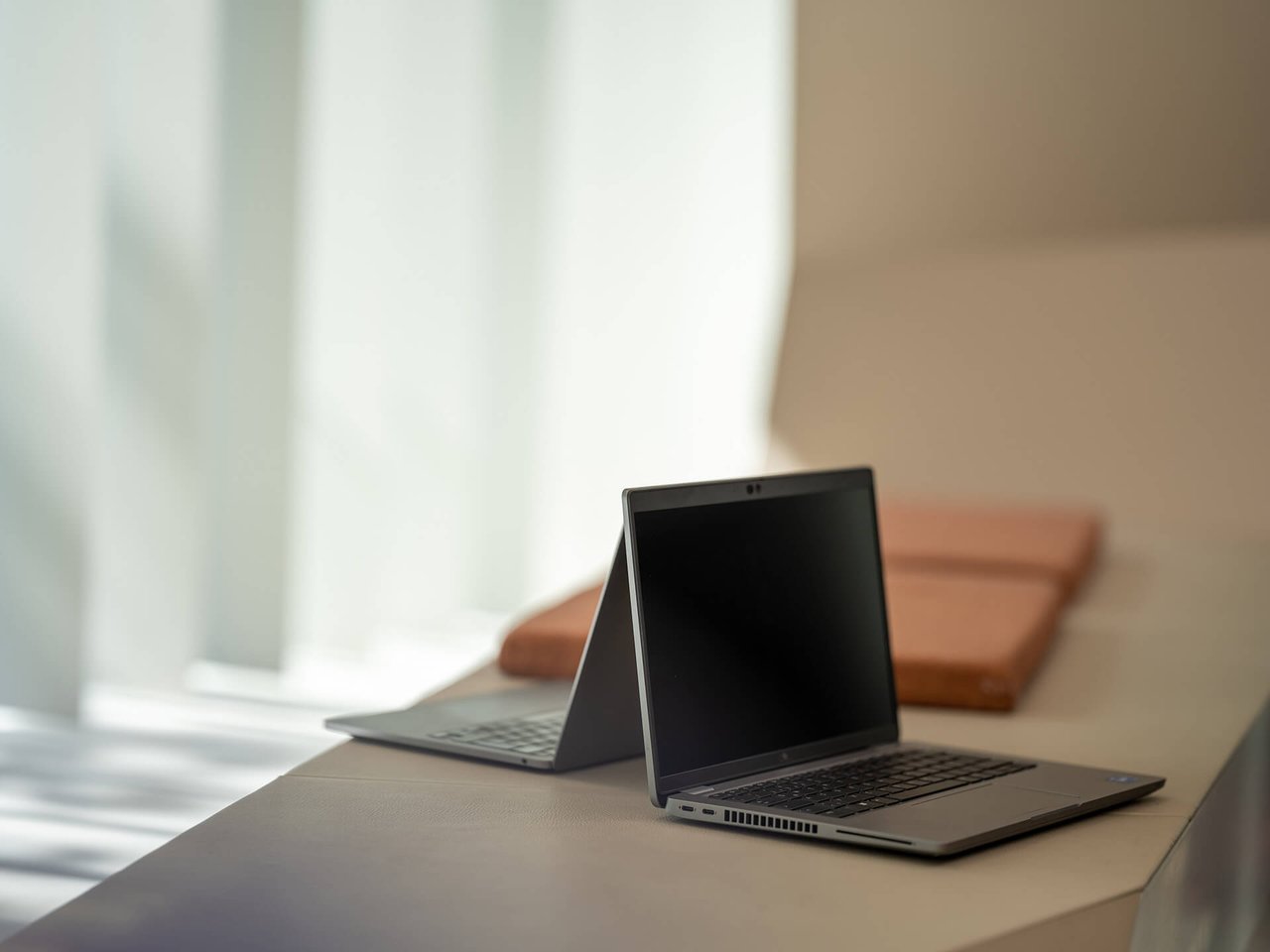 Zwei Notebooks auf einer Sitzgelegenheit in einem Büro