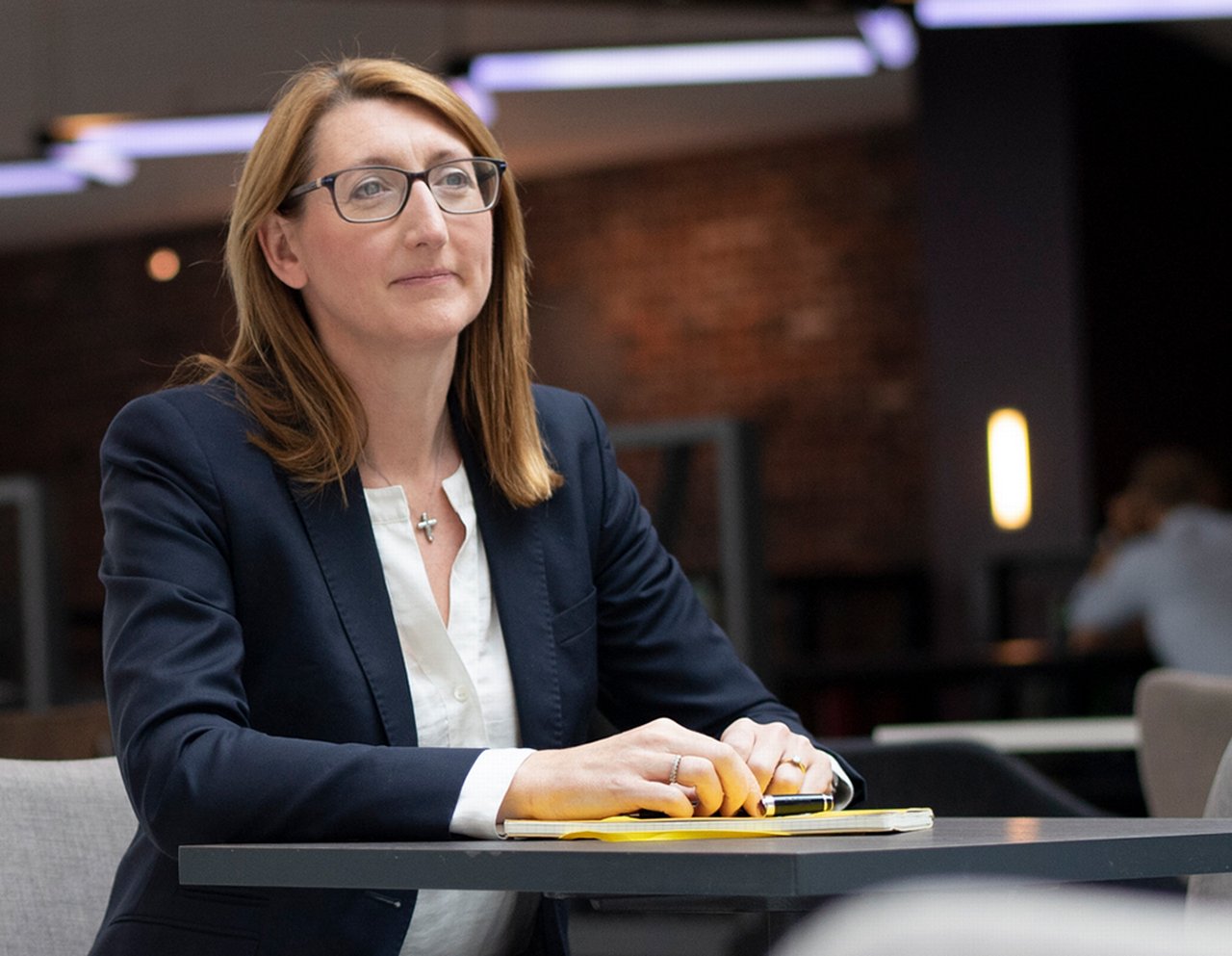 Deirdre is sitting at table with paperwork in front of her