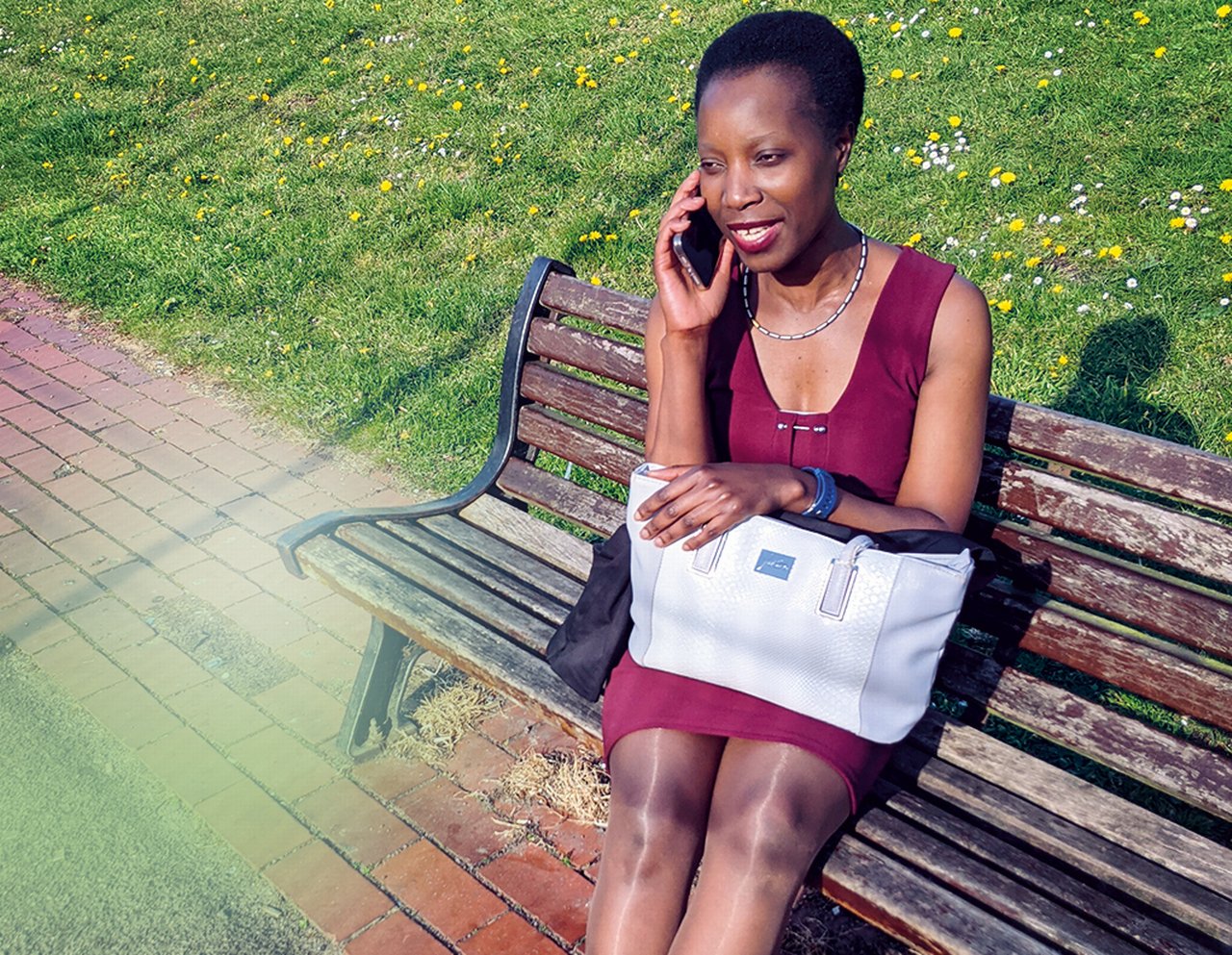 Melinda making a phone call on a park bench