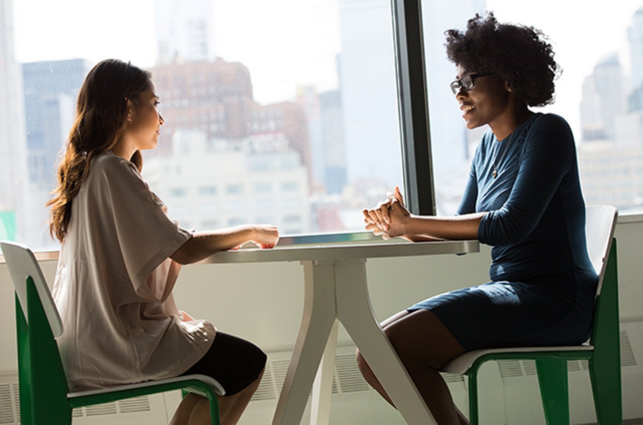 Two female colleagues in discussion at a table