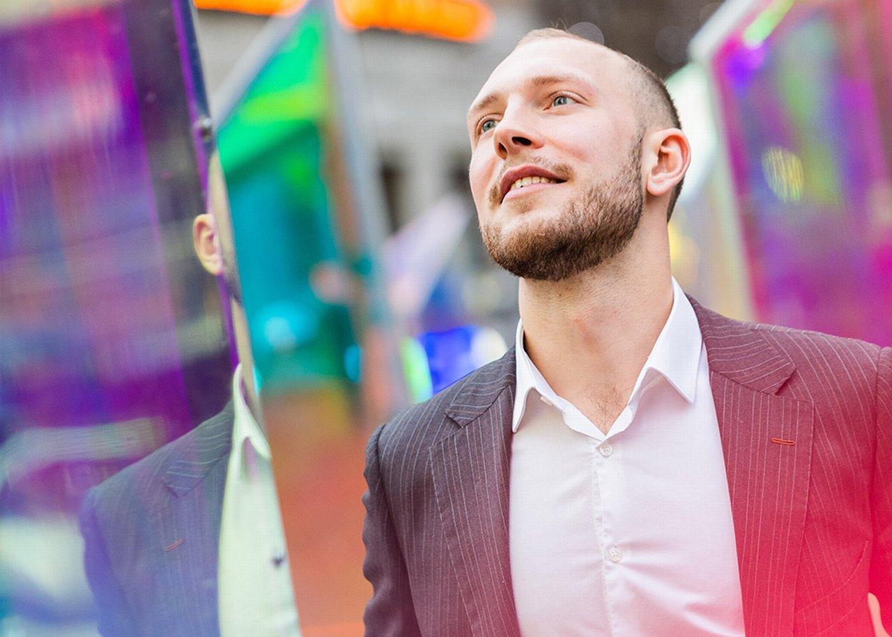 German is standing next to colorful mirrors