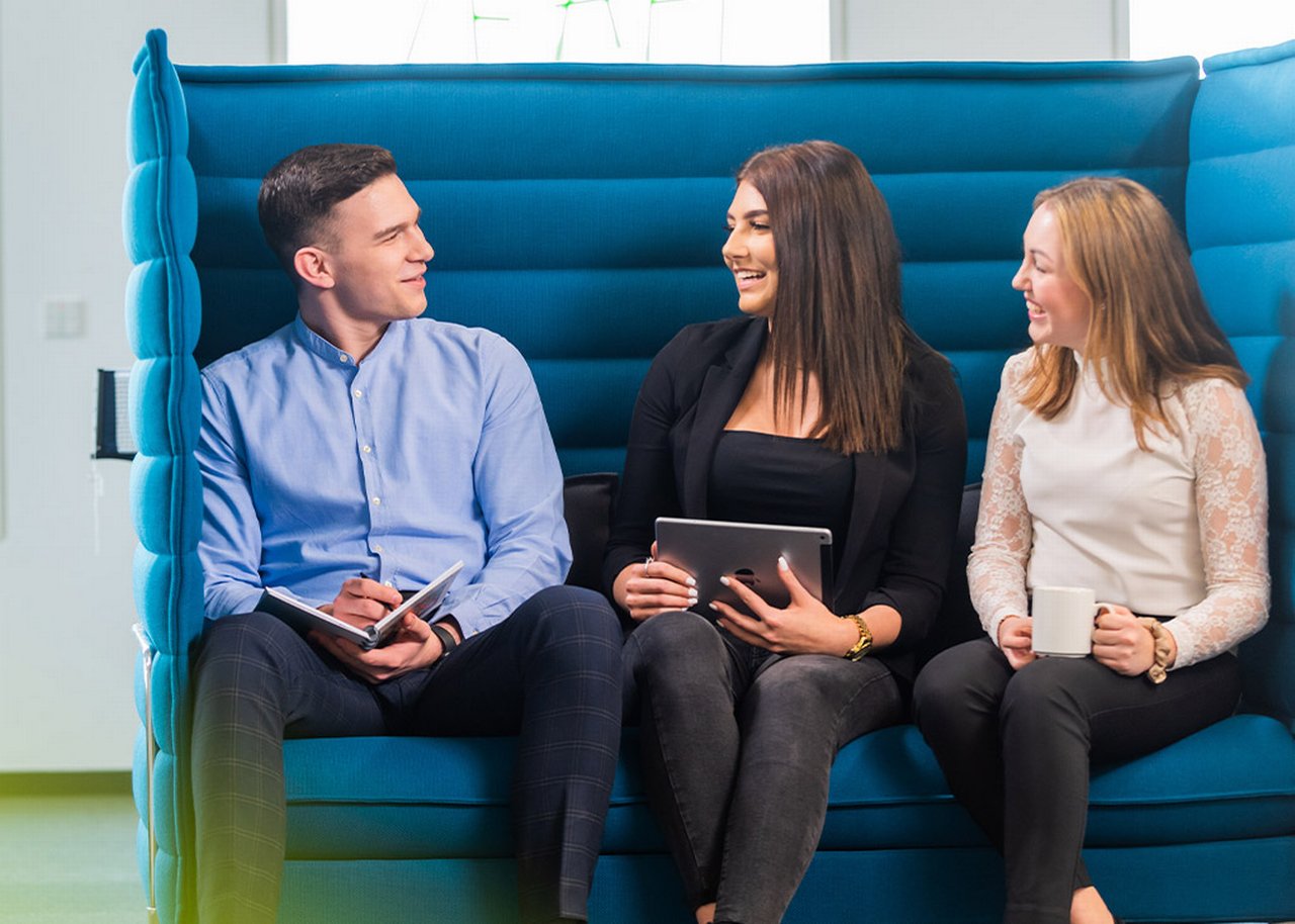 Justin with his colleagues on a big blue sofa