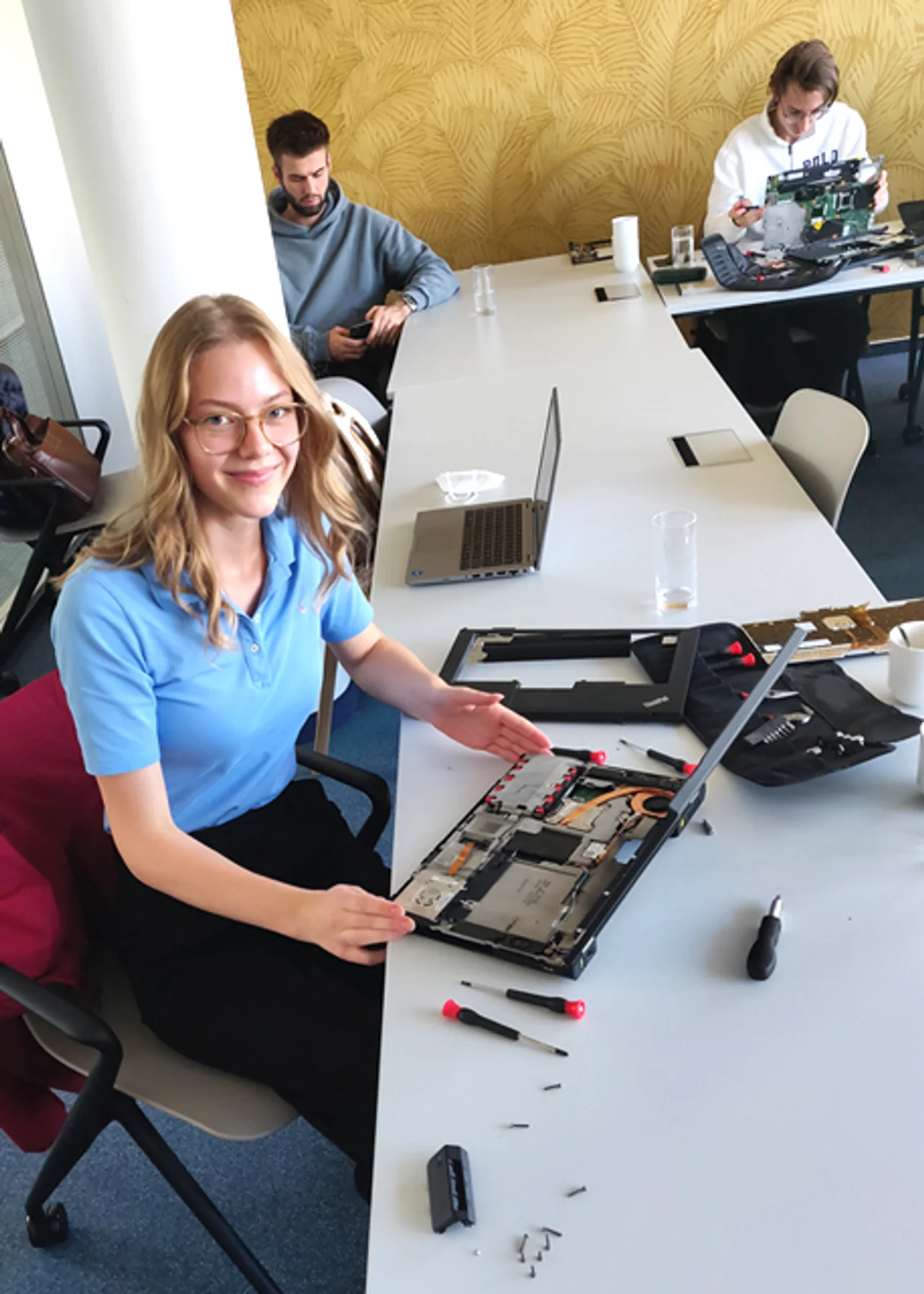 Nina am Schreibtisch mit Laptop und Schraubenzieher