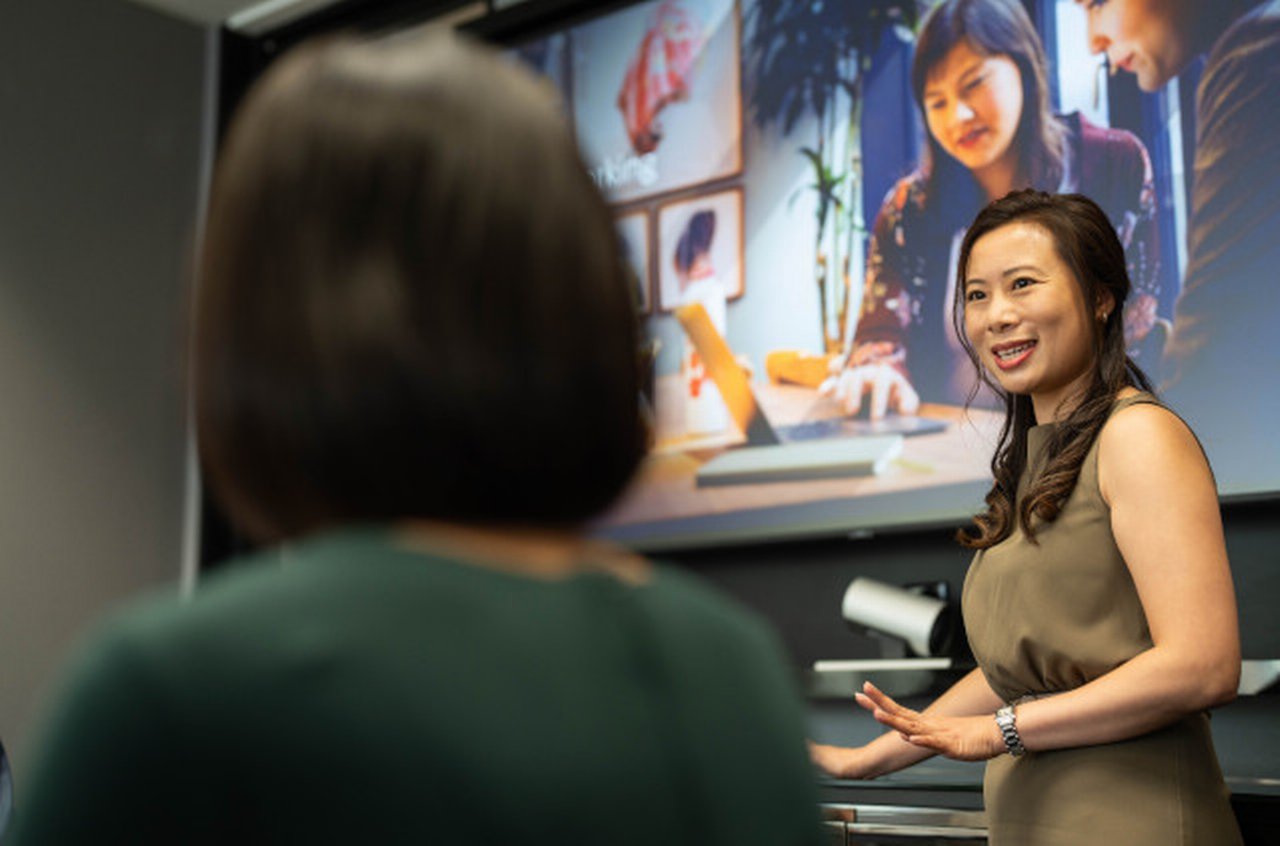 Women holds a presentation in front of colleagues at Deutsche Bank office in Hong Kong