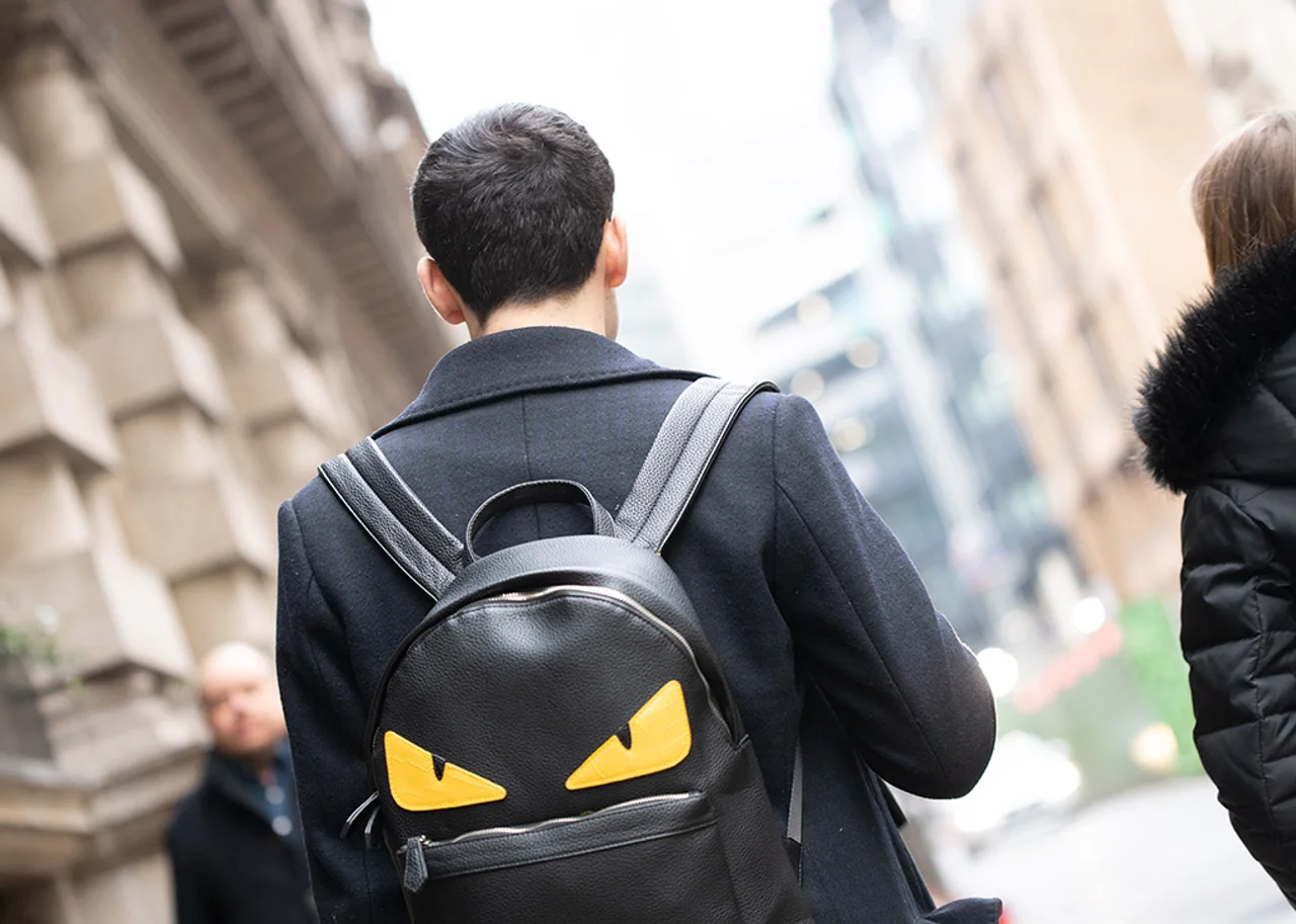 Adam mit Rucksack in der Stadt