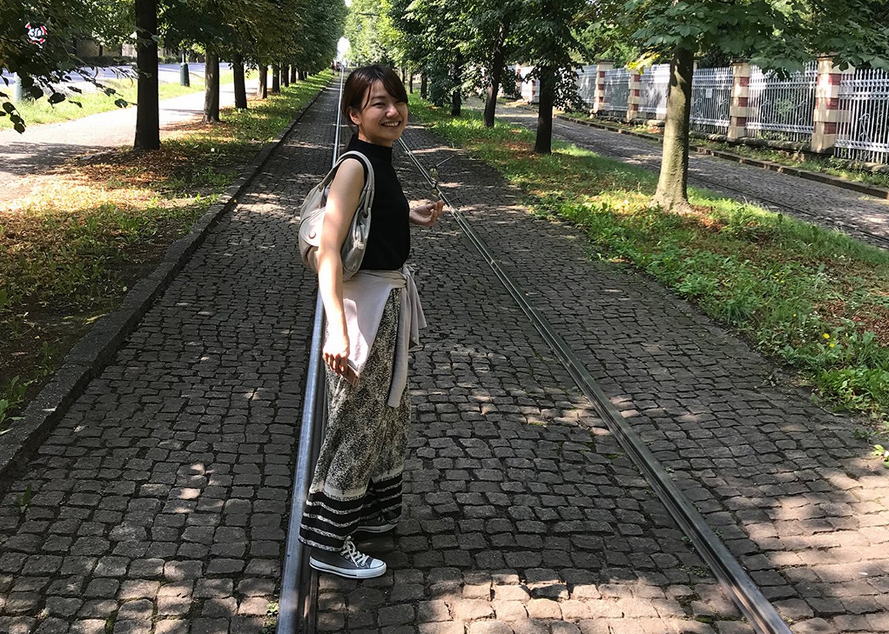 Kyoko steht in einem Park