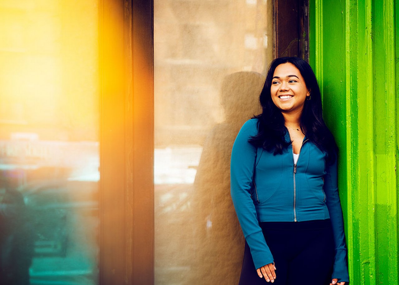 Camila smiles in front of a colorful wall