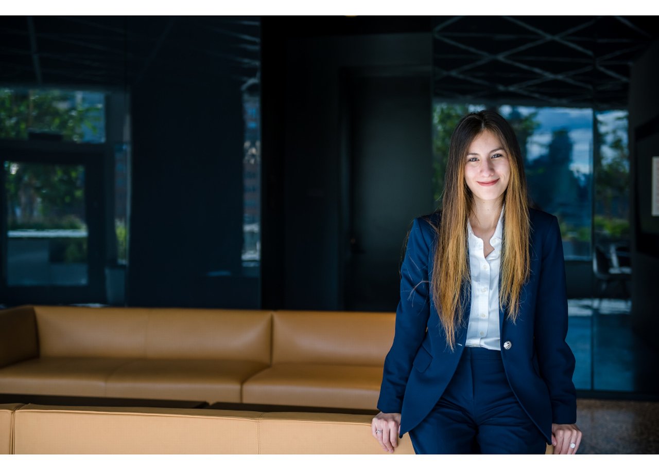 Isabel lächelt, während sie sich auf ein Sofa lehnt