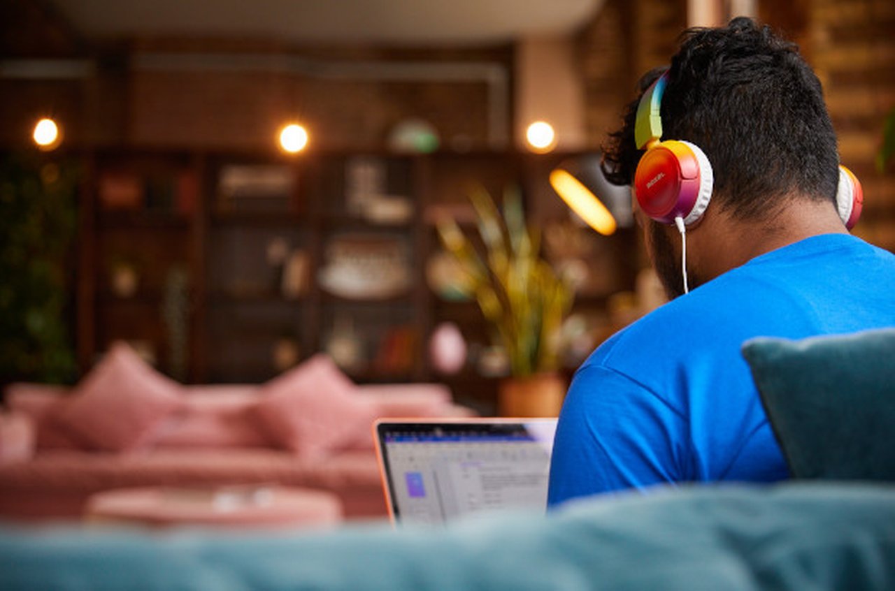 Back of the man working in laptop headphones on