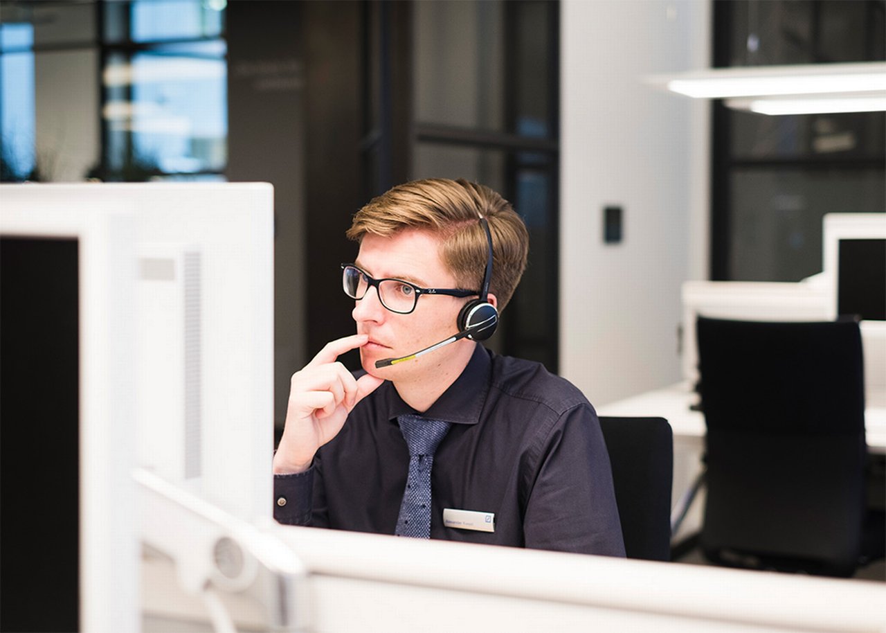 Alexander arbeitet an seinem Computer mit einem Headset
