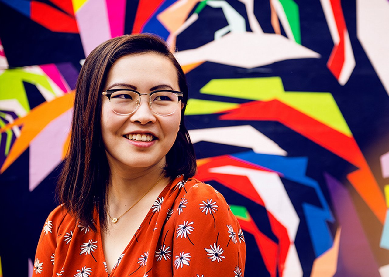 Tina in front of a colorful wall drawing