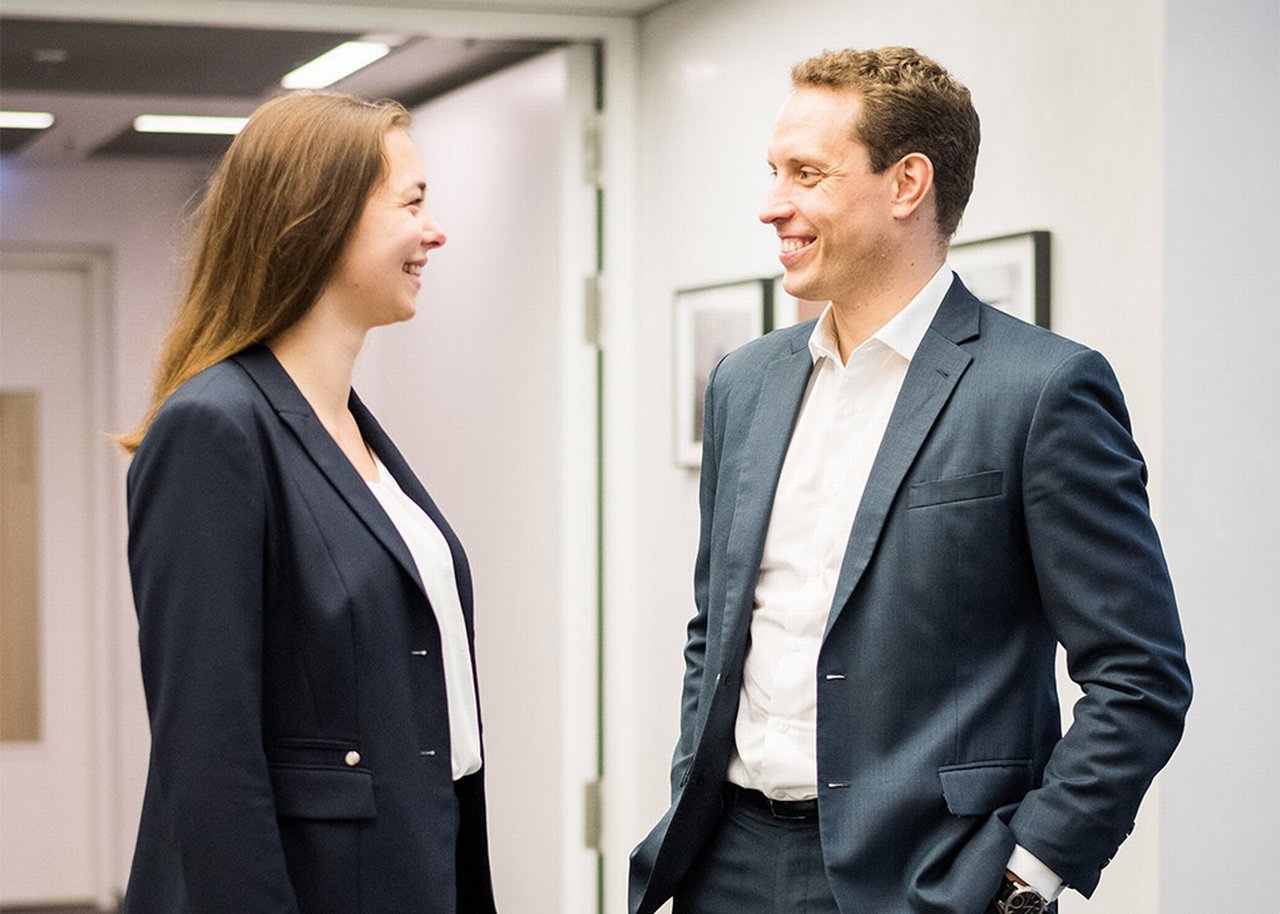 Giulia lächelt im Gespräch mit einem Kollegen