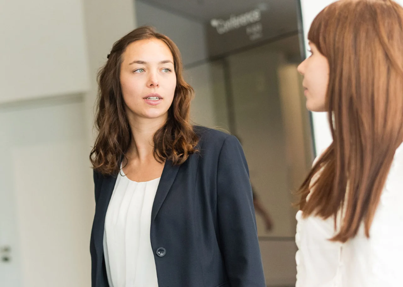 Giulia in conversation with a colleague and looking attentive