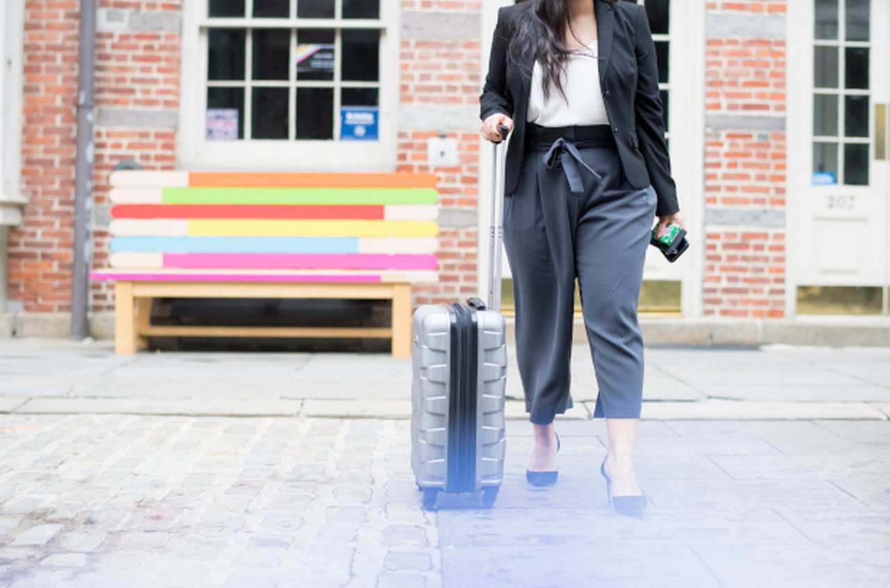 Woman walks in London Streets with Suitcase