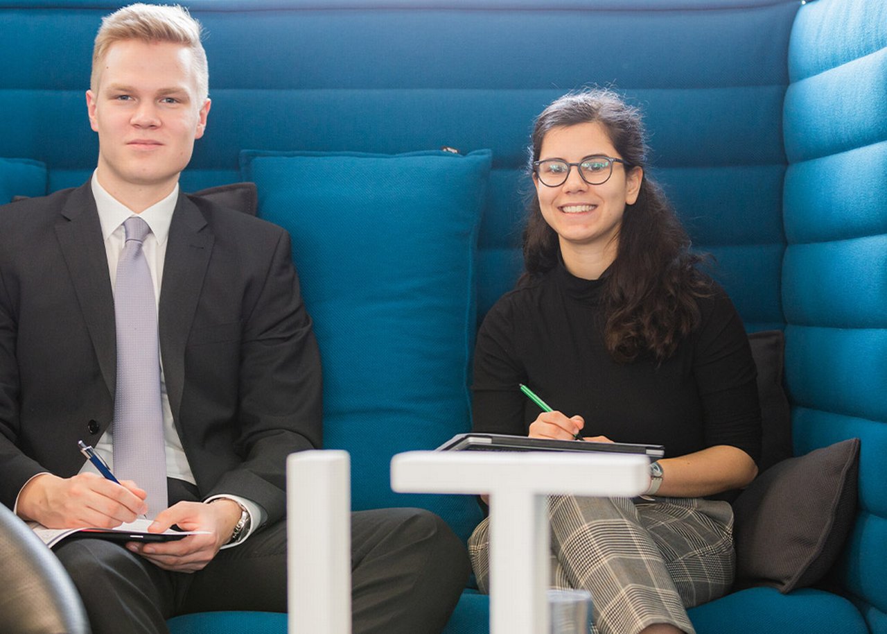 Sofie smiling with her colleague taking notes