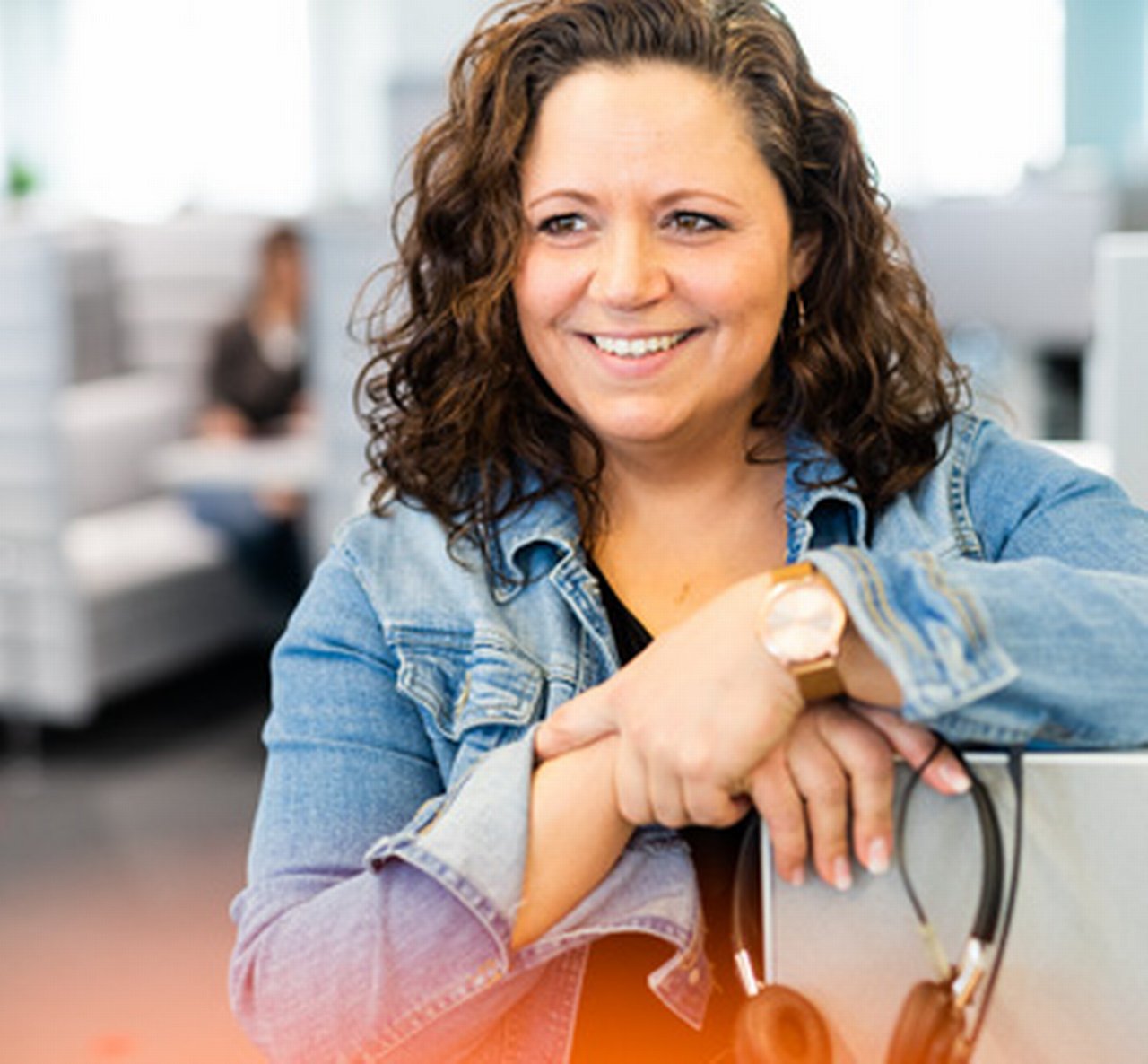 Katharina leans casually against a screen, her headset in hand