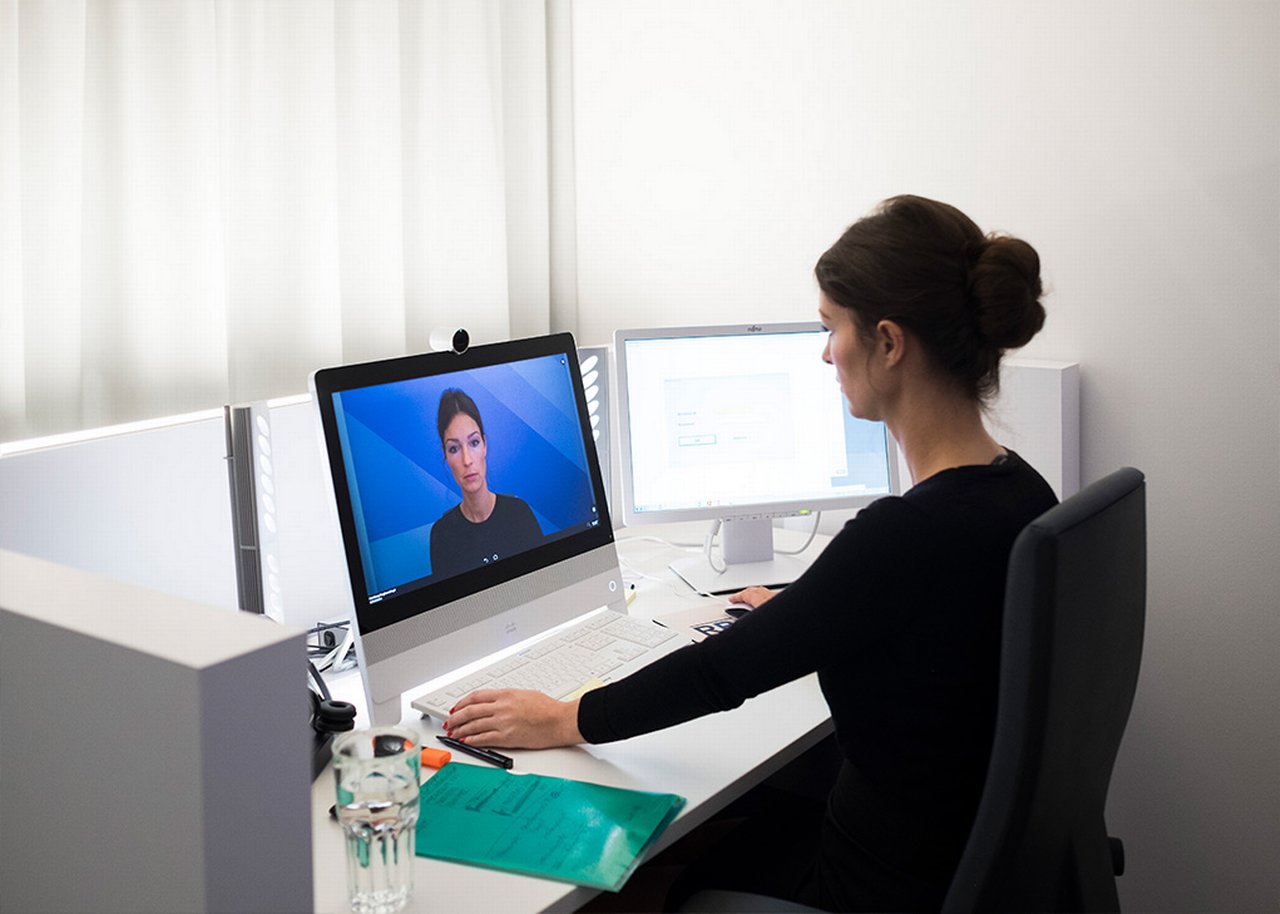 Juliane is sitting at her desk during a video call