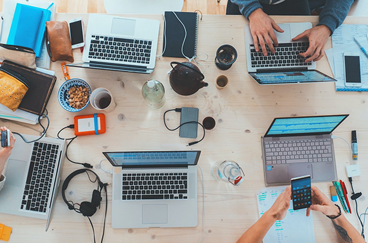 Multiple laptops and electronic devices on a table
