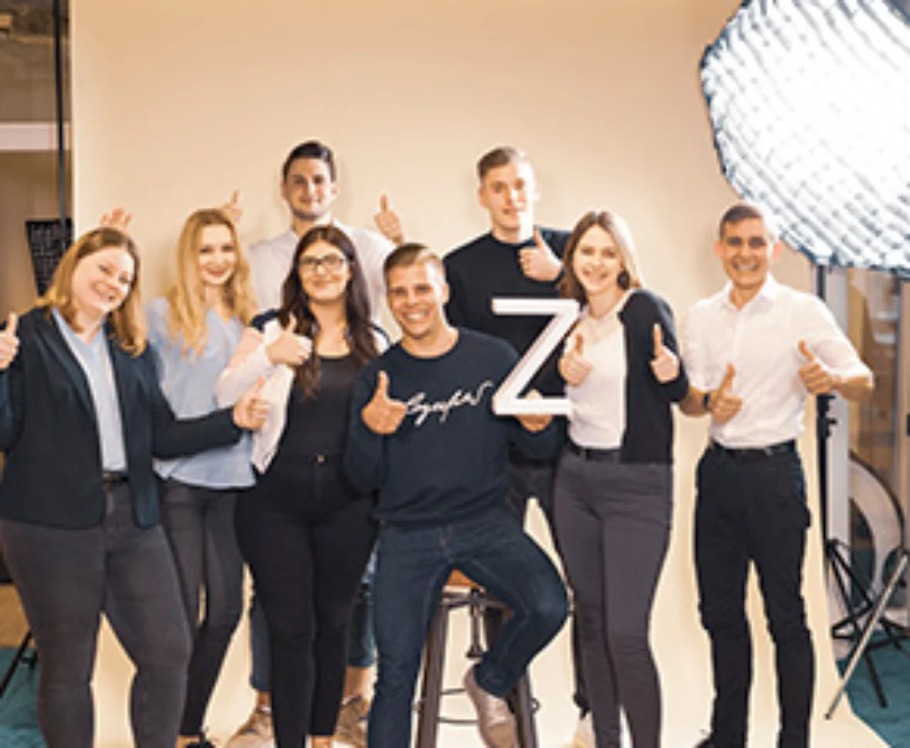 Azubis mit Daumen hoch während eines Fotoshootings