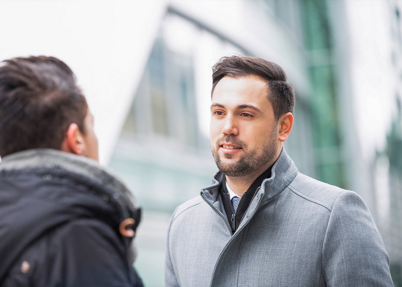 Semi is outside a glass building in conversation