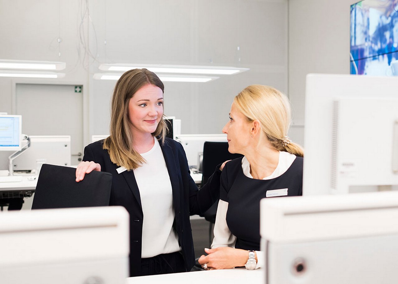 Marleen is talking to a colleague in an office furnished in white
