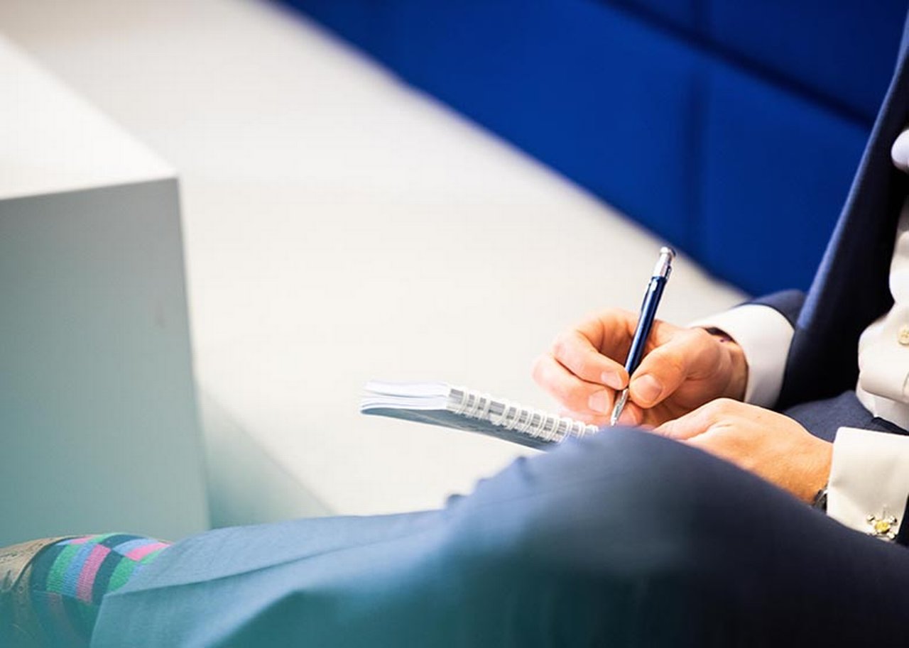 A person writes in a notepad