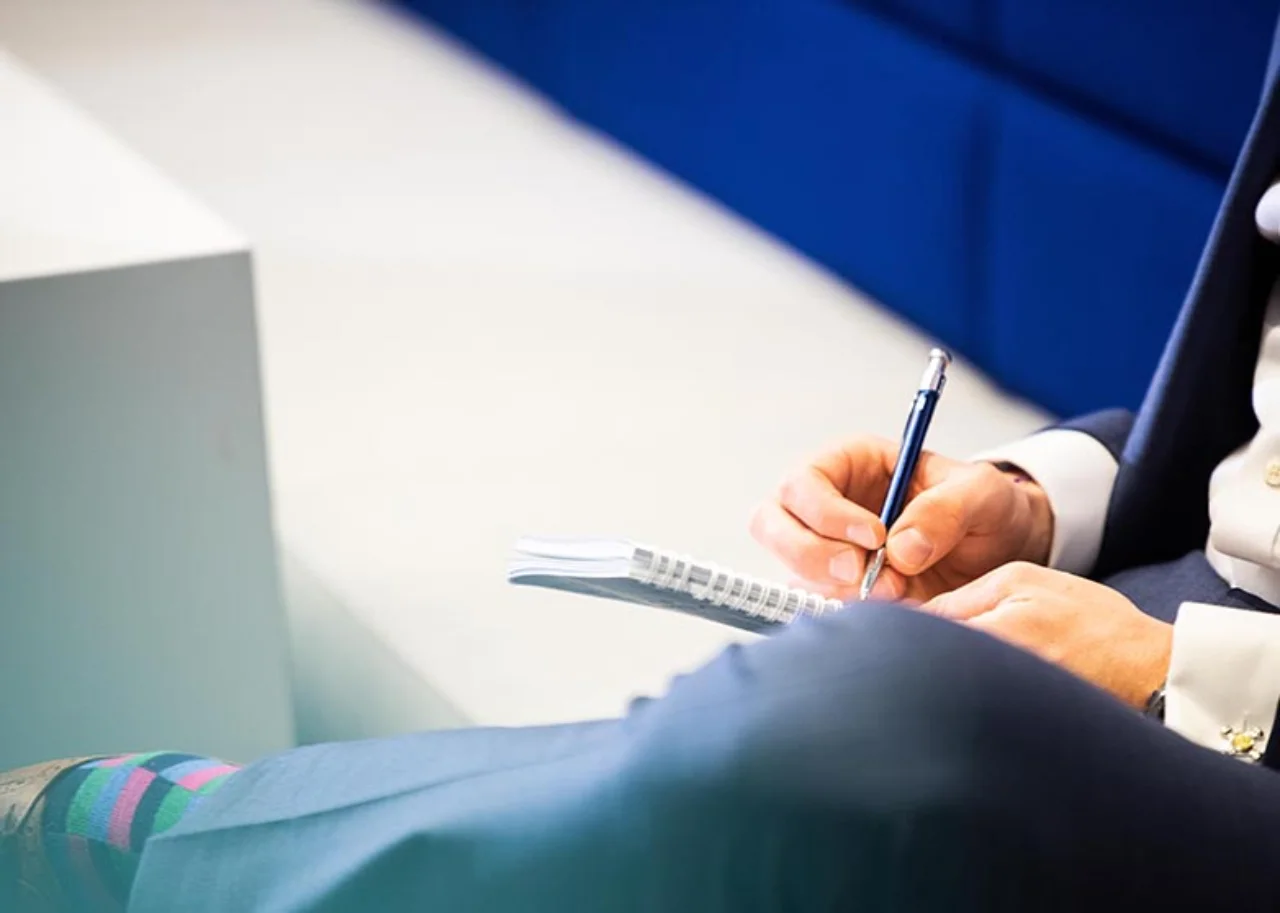 A person writes in a notepad