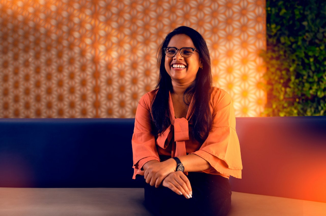 smiling employee sits in the Deutsche Bank branch in Bangalore