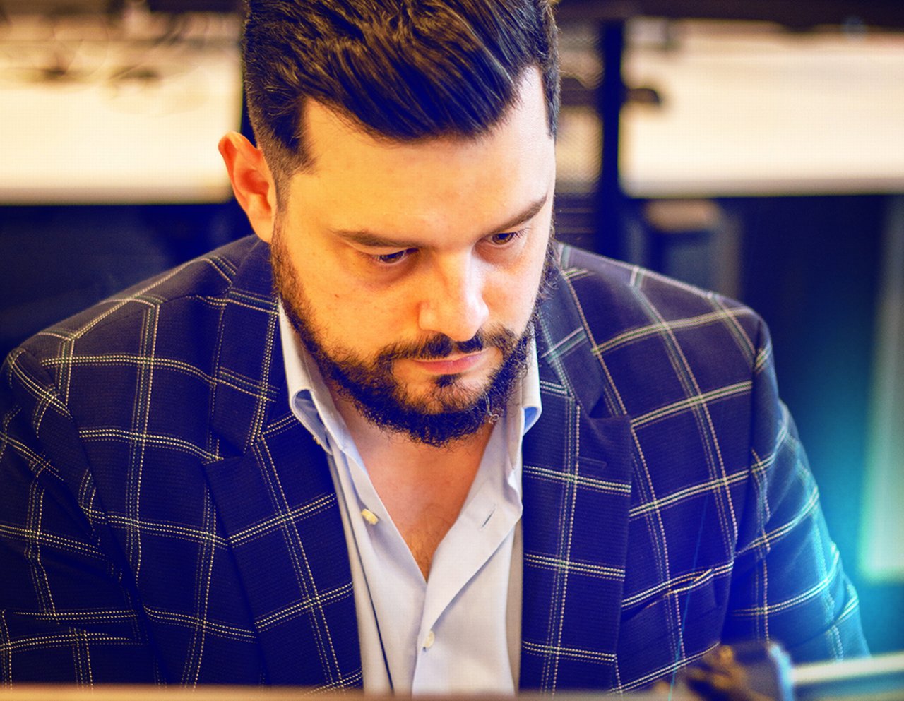 Mihai concentrates in a plaid suit