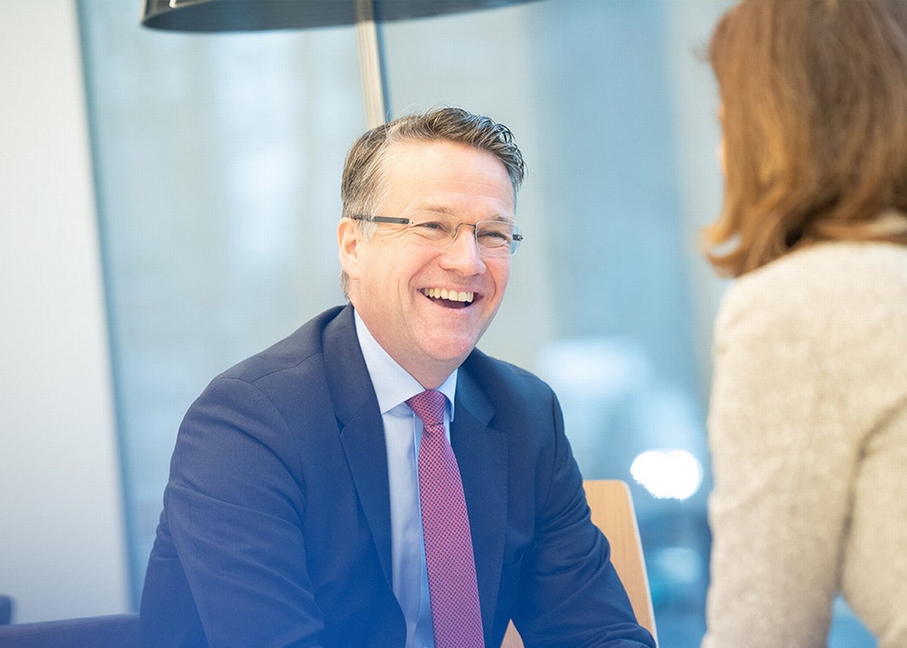 Frank lachend in einem Business Meeting