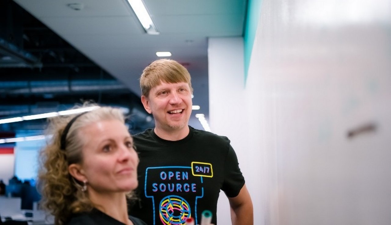 A woman and a man standing in front of a whiteboard