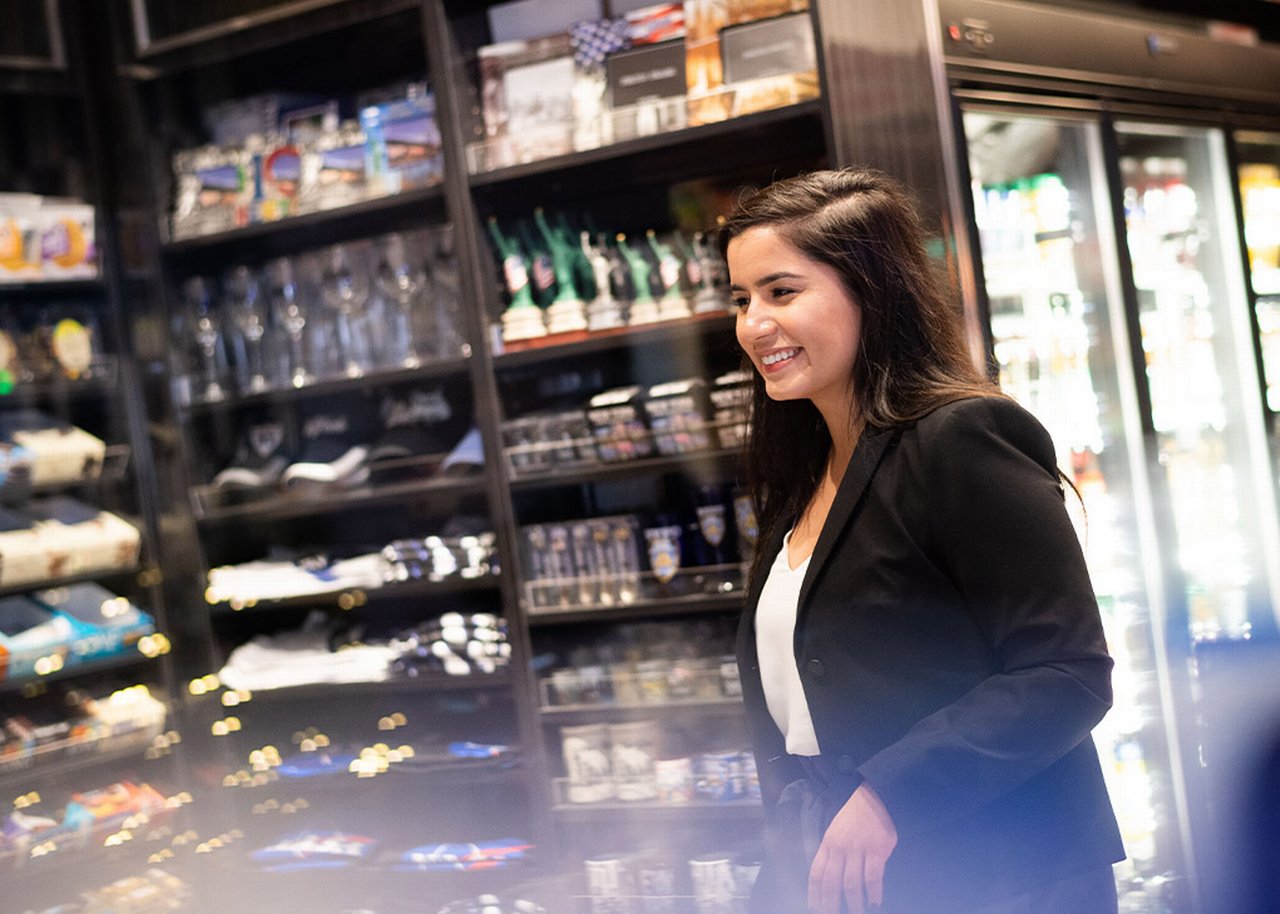 Monica is standing inside of a shop and smiling