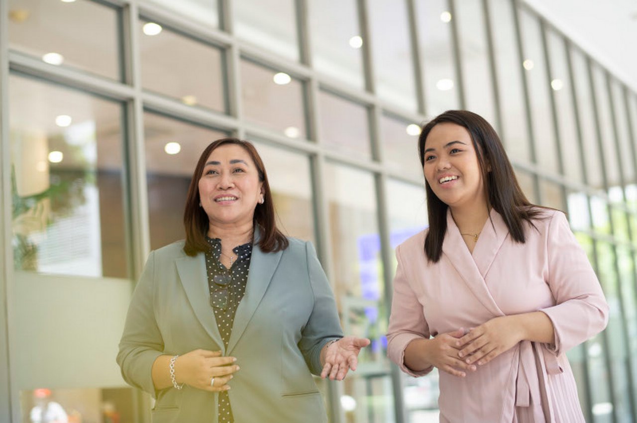 Two colleagues talk while walking