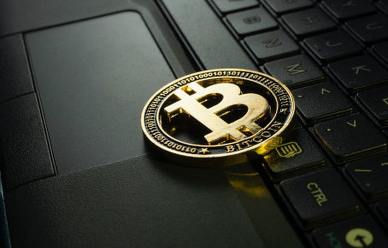 a golden bitcoin on a keyboard